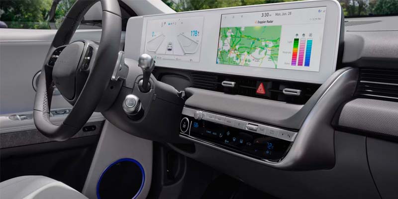 Interior view of an electric vehicle showing digital dashboard and infotainment screens.